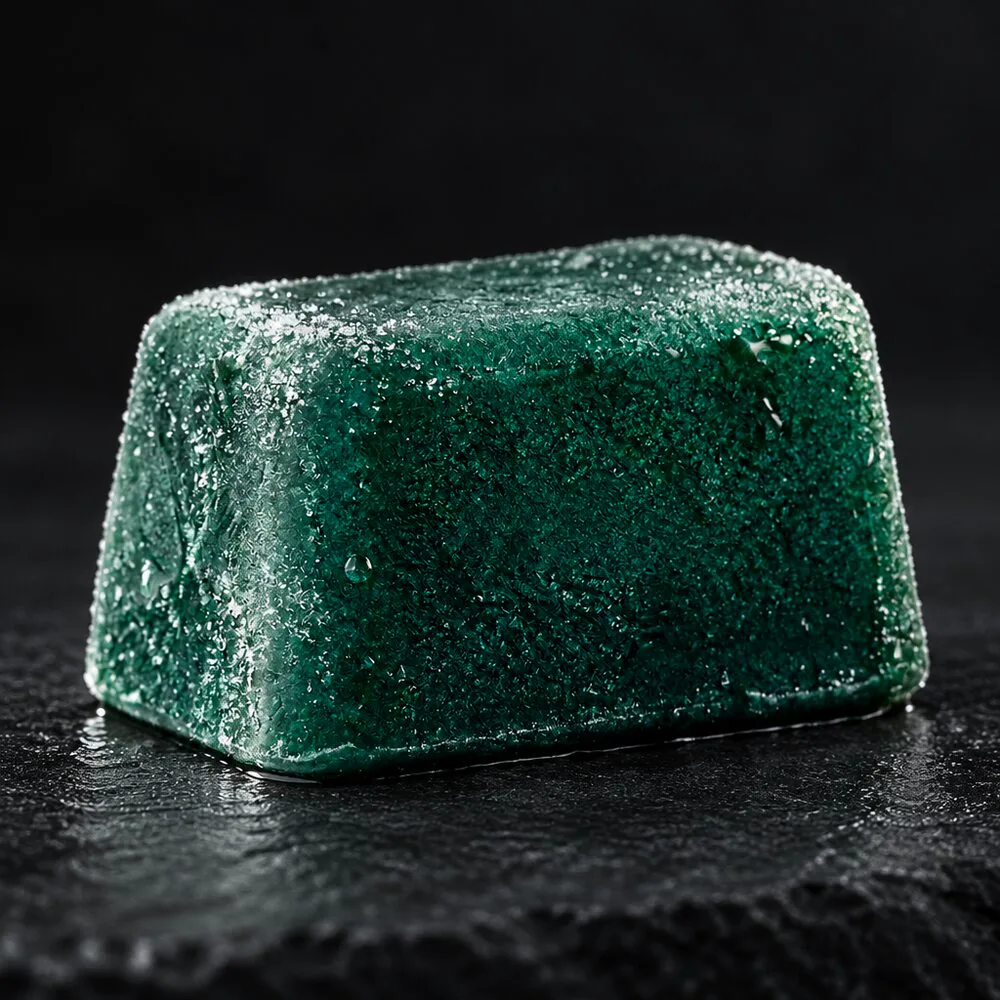 Macro close-up of a frosted rectangular fresh-frozen spirulina cube